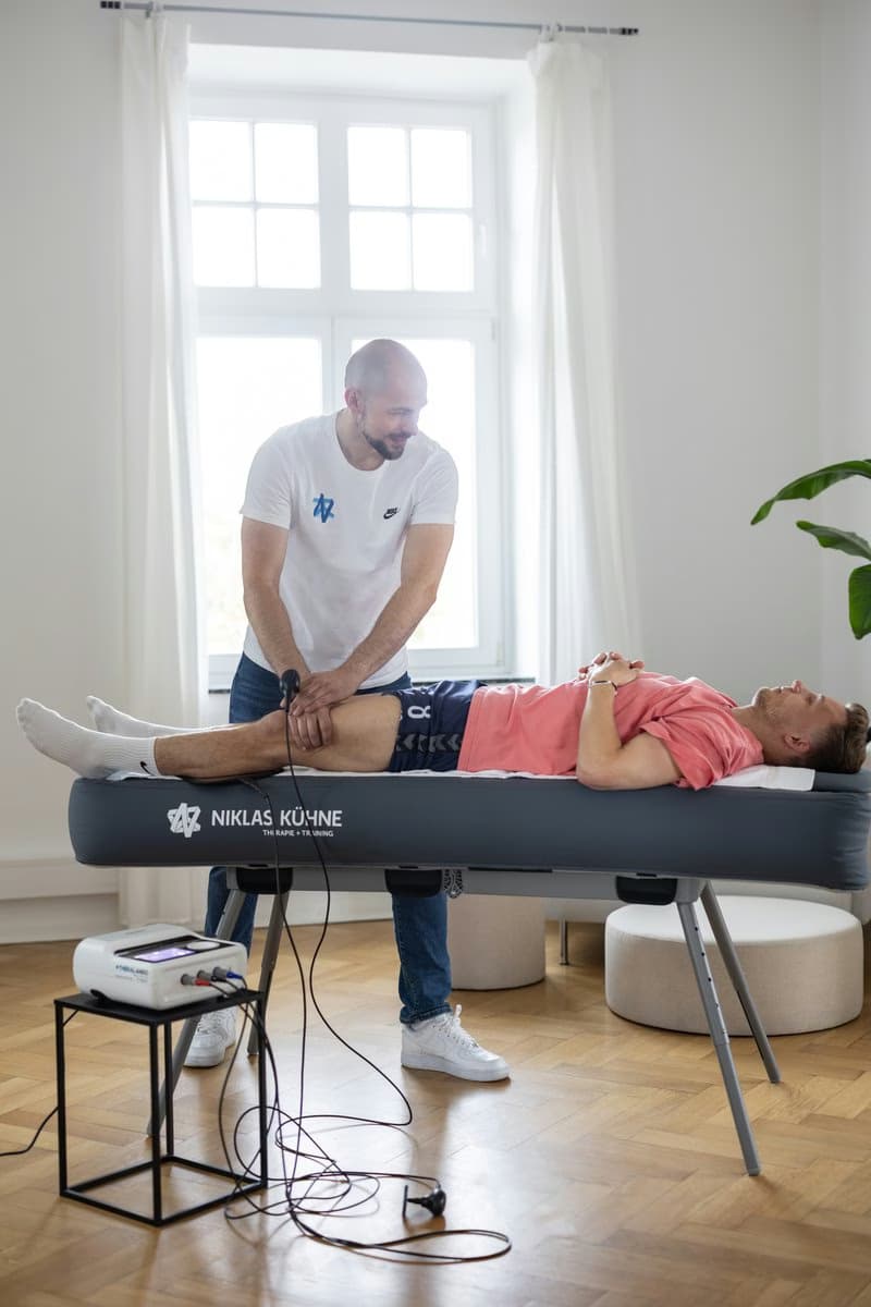 Niklas Kühne behandelt einen Sportler auf der mobilen Behandlungsliege